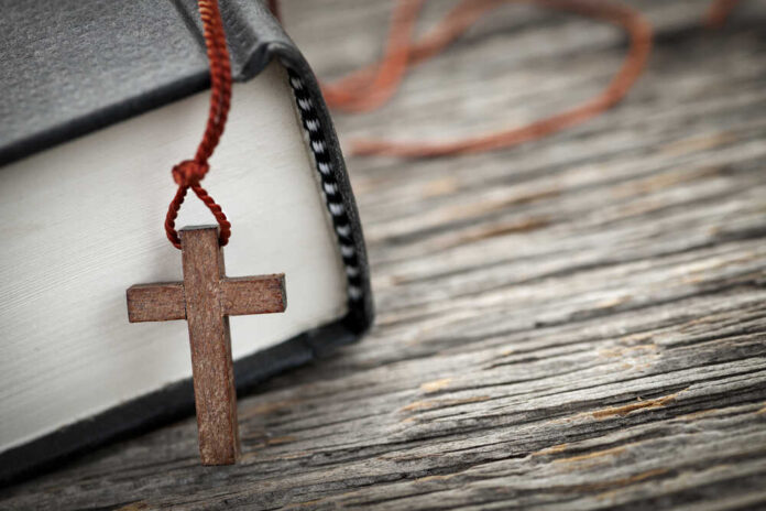 Closeup,Of,Wooden,Christian,Cross,Necklace,Next,To,Holy,Bible