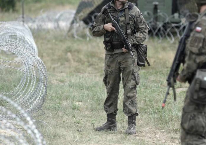 Soldiers,Of,Poland,On,Border.,Polish,Soldiers,Near,A,Fence