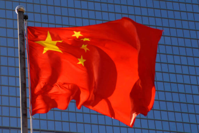 Chinese,Flag,With,A,Modern,Office,Building,Backdrop.