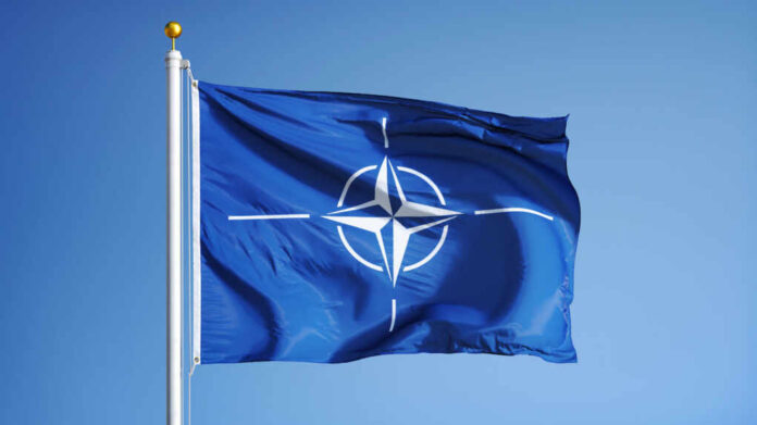 Nato,Flag,Waving,Against,Clean,Blue,Sky,,Close,Up,,Isolated