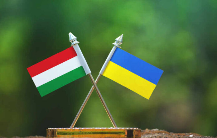 Ukraine,And,Hungary,Small,Flag,With,Blur,Green,Background