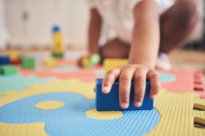 Building,Blocks,,Hands,And,Toddler,At,Daycare,With,Development,On