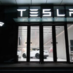 Tesla showroom featuring a white electric vehicle displayed under bright lights