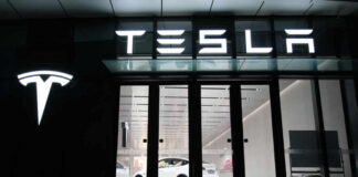 Tesla showroom featuring a white electric vehicle displayed under bright lights