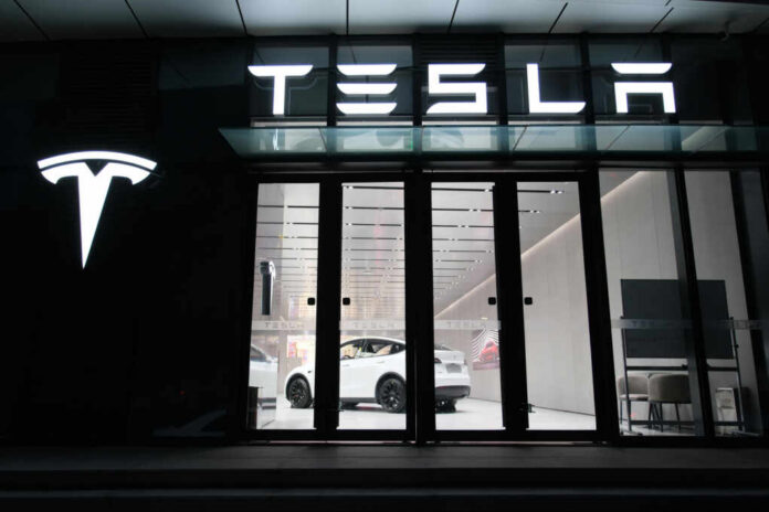 Tesla showroom featuring a white electric vehicle displayed under bright lights
