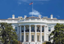 Anti-Zionist Views Spark White House Turmoil The White House with an American flag flying against a blue sky