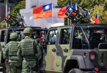 Trump’s Taiwan Decision: Strength or Weakness? Soldiers in camouflage uniforms standing near military vehicles with flags in the background