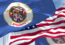 Minnesota state flag in front of American flags