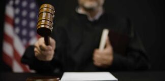 A judge holding a gavel in a courtroom setting