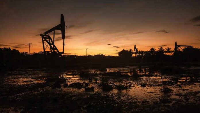 Silhouette of oil pumps against a sunset sky
