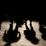 Population Bomb Author Dies Amid Failed Prophecies Silhouettes of people walking on a street, casting long shadows