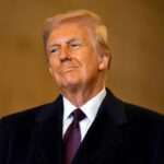 Trump’s Bold Move: Saved Congressman Dunn’s Life! A man in formal attire smiling confidently against a neutral background