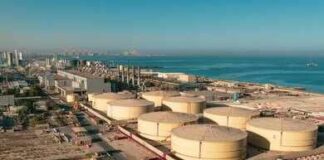 Aerial view of large oil storage tanks near a coastal area