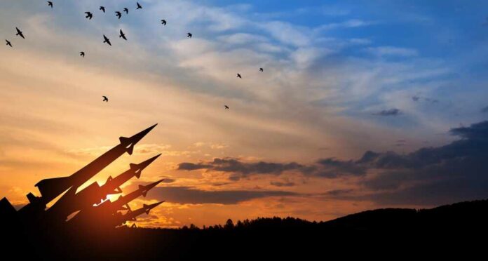 Silhouette of missiles against a colorful sunset with birds flying
