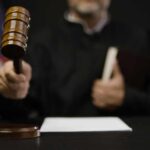 A judge holding a gavel in a courtroom setting