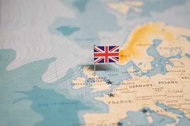 shutterstock_2324819355.jpg A map of Europe with a small flag of the United Kingdom pinned on it