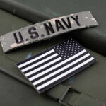 U.S. Navy patch and American flag on a green surface