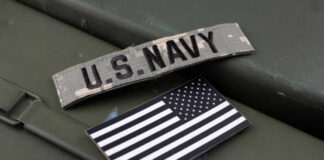 U.S. Navy patch and American flag on a green surface