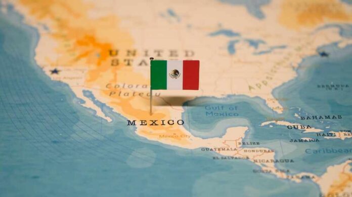 shutterstock_2406904423.jpg Map of North America with a flag of Mexico pinned on it