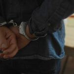 Illegal Immigrant Kills Again — 30 Arrests Ignored Hands behind back in handcuffs, indicating an arrest