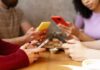 Group of friends sitting at a table, each using their smartphones