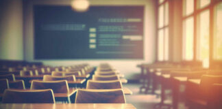 Empty classroom with wooden desks and chairs, illuminated by natural light