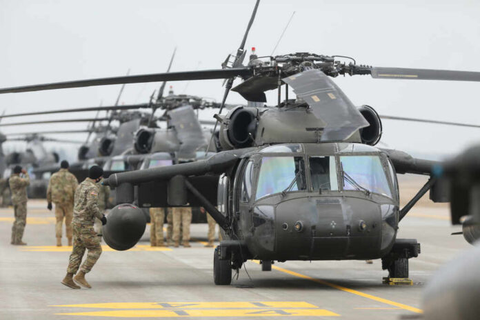 Military personnel preparing helicopters on an airbase