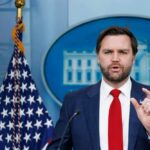 Government official speaking at a press conference in front of the White House