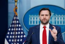 Government official speaking at a press conference in front of the White House
