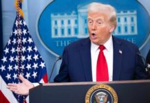 A man speaking at a podium during a press conference at the White House