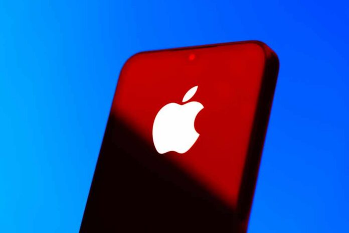 shutterstock_2604050313.jpg Close-up of a smartphone with the Apple logo against a red and blue background