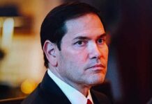 A serious-looking man in formal attire with a focused gaze