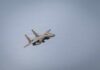 A military fighter jet flying against a clear sky