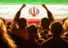 Crowd of people raising their fists in front of the Iranian flag