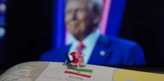 Map of Iran with push pins and a blurred figure in the background