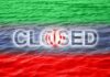 Graphic representation of the word 'CLOSED' overlaid on the Iranian flag with a water background