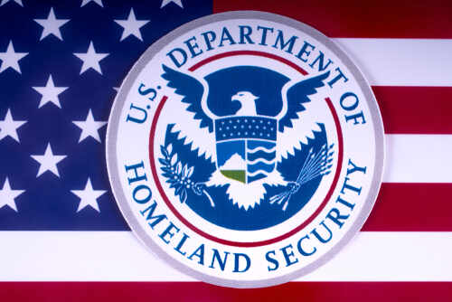 U.S. Department of Homeland Security emblem on a background of the American flag