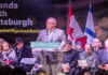 A speaker addressing a crowd at a community event against antisemitism in Toronto