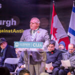 Prince Harry Sparks Outrage With Antisemitism Warning A speaker addressing a crowd at a community event against antisemitism in Toronto