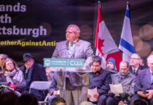 A speaker addressing a crowd at a community event against antisemitism in Toronto