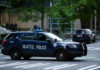 Seattle police SUV parked on a city street with blue lights flashing