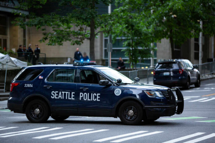 Seattle police SUV parked on a city street with blue lights flashing