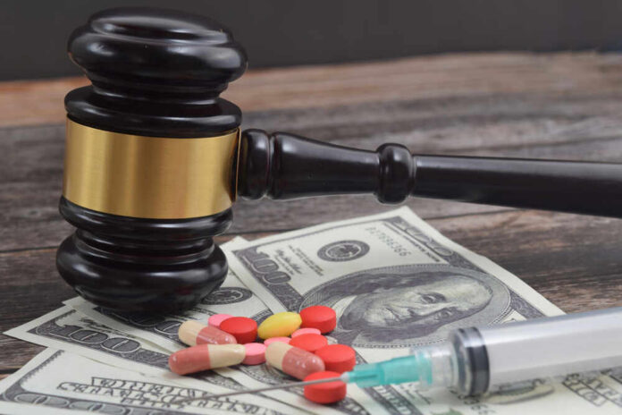 A gavel placed on top of money with pills and a syringe nearby