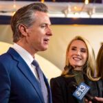 California’s Quiet Big Oil Payout? A man speaking at a public event with two women nearby, one smiling and another looking down