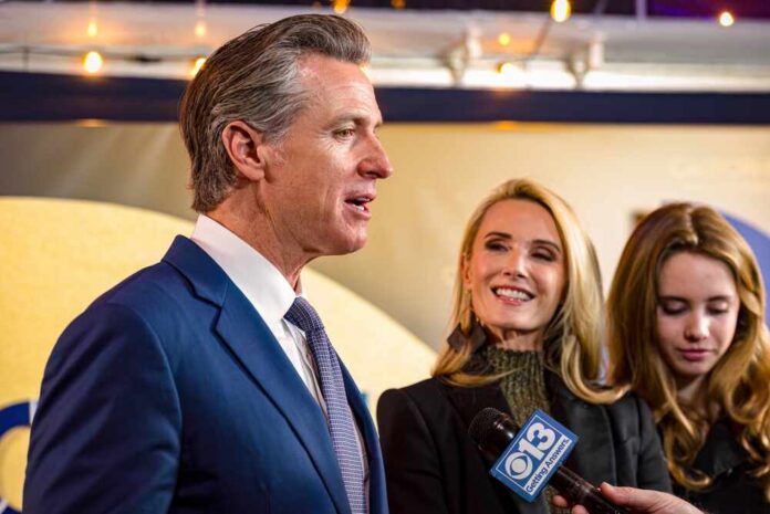Sacramento,,Ca,,U.s.a.,-,Feb.,6,,2024:,Governor,Gavin,Newsom A man speaking at a public event with two women nearby, one smiling and another looking down