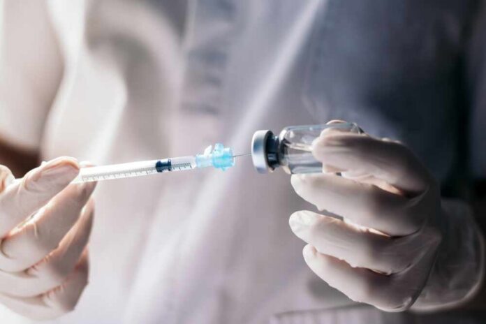 A healthcare professional preparing a syringe from a vial