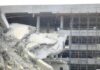 Damaged building structure with exposed debris and scaffolding