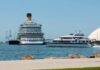 A large cruise ship and a ferry docked in a harbor