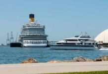 A large cruise ship and a ferry docked in a harbor