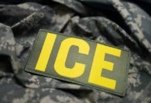 Close-up of a military patch with the letters ICE on a camouflage background
